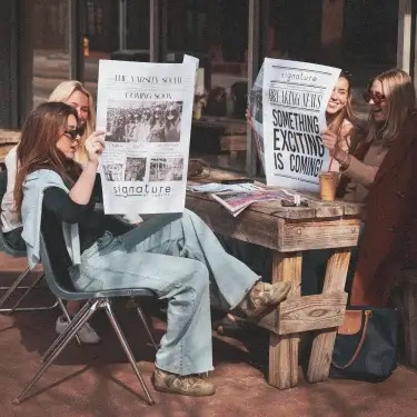 signature at varsity off campus apartments near nc state lifestyle shoot girls reading newspaper